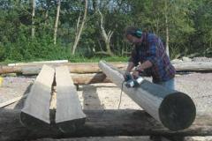 Planing the logs. (halved logs act as base plates)